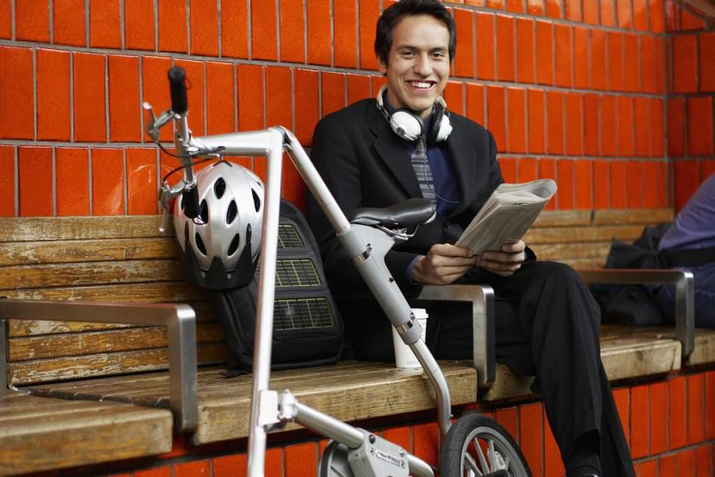 Smiling man with a folding bike