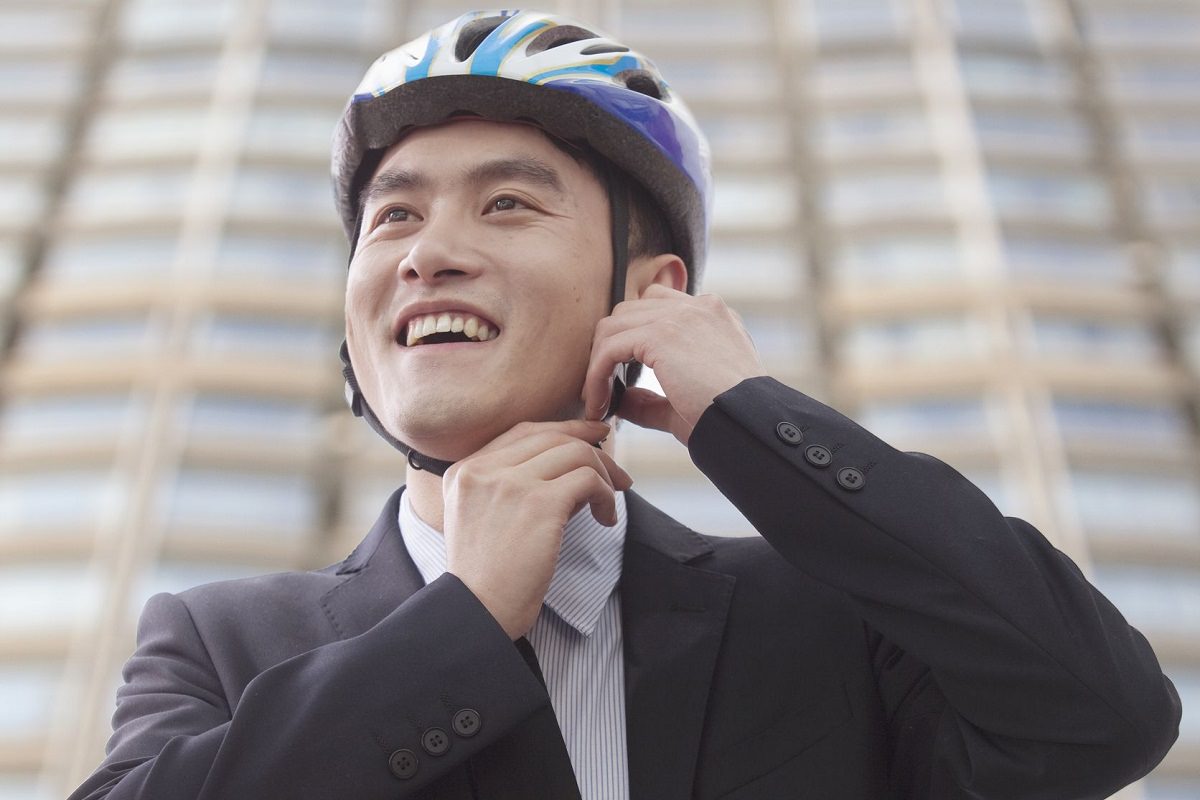 Businessman putting on cycling helmet