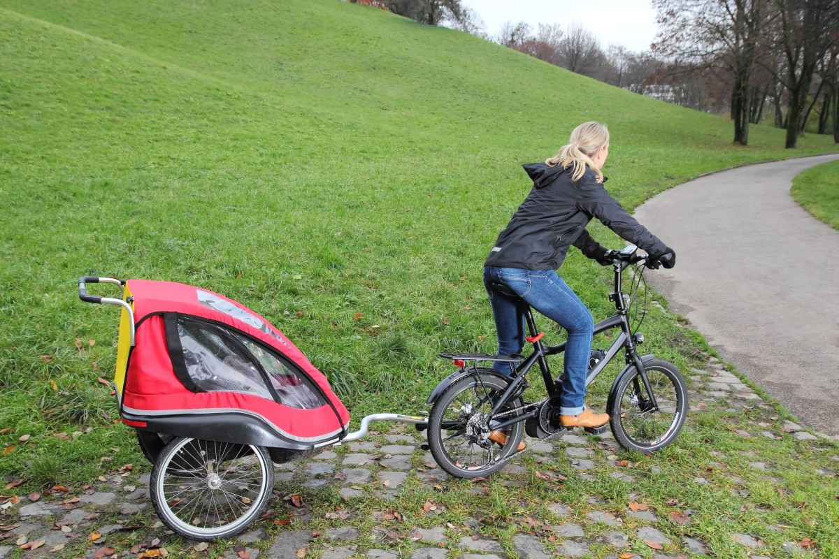 Mother riding ebike with child trailer