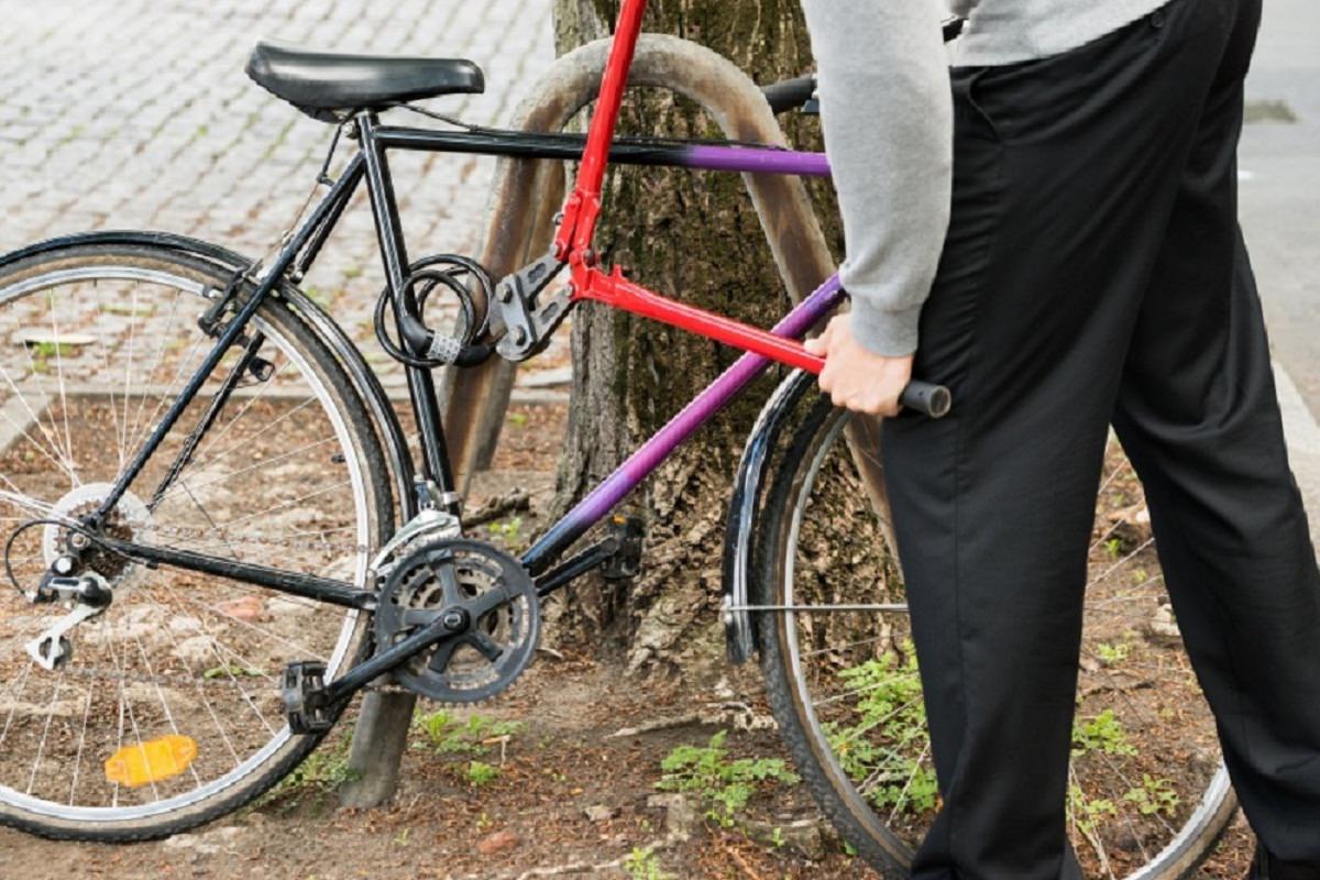 Thief trying to break bike lock with pliers