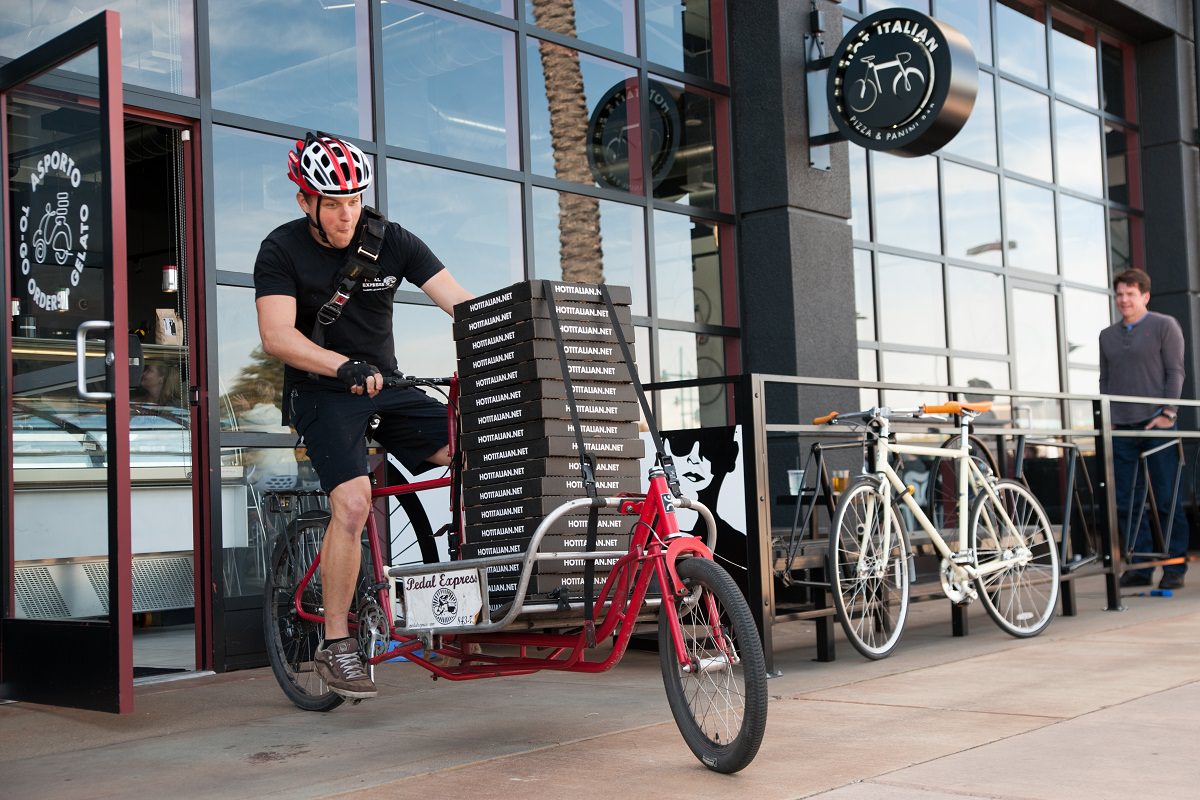 Delivery boy with orders in his cargo bike