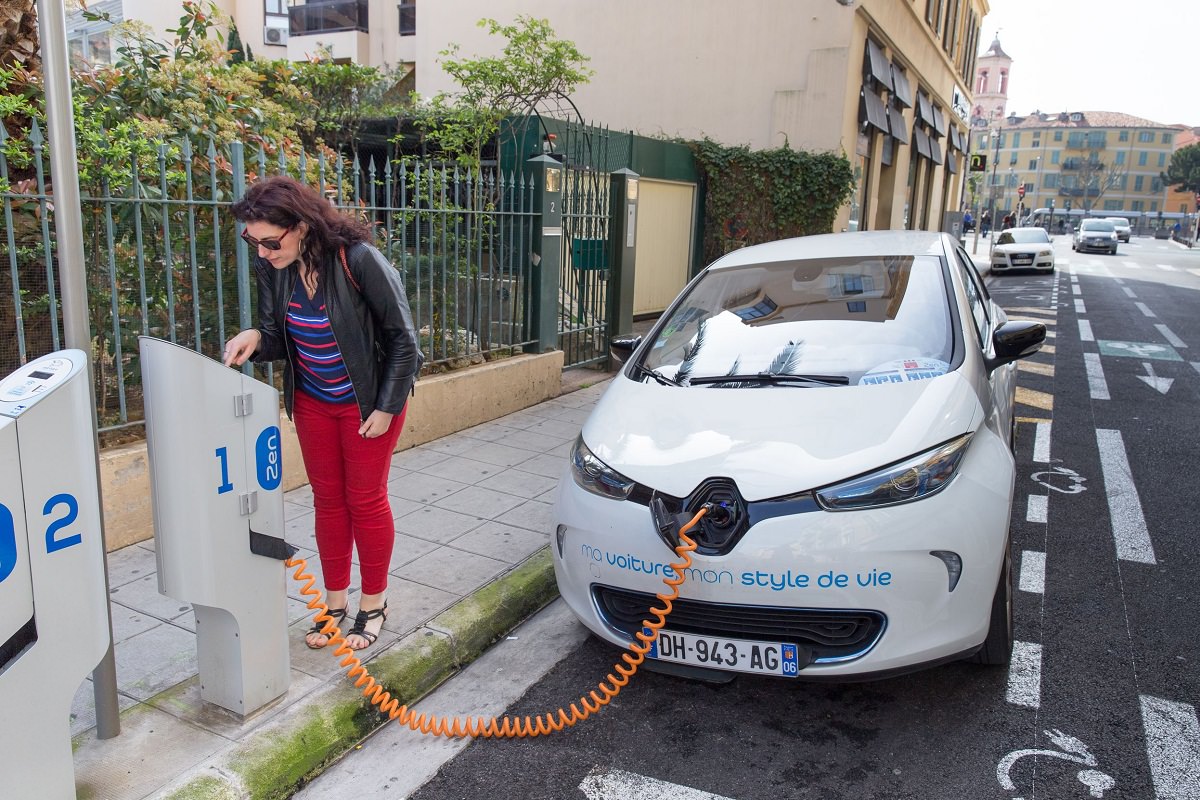 Woman charging her electric car