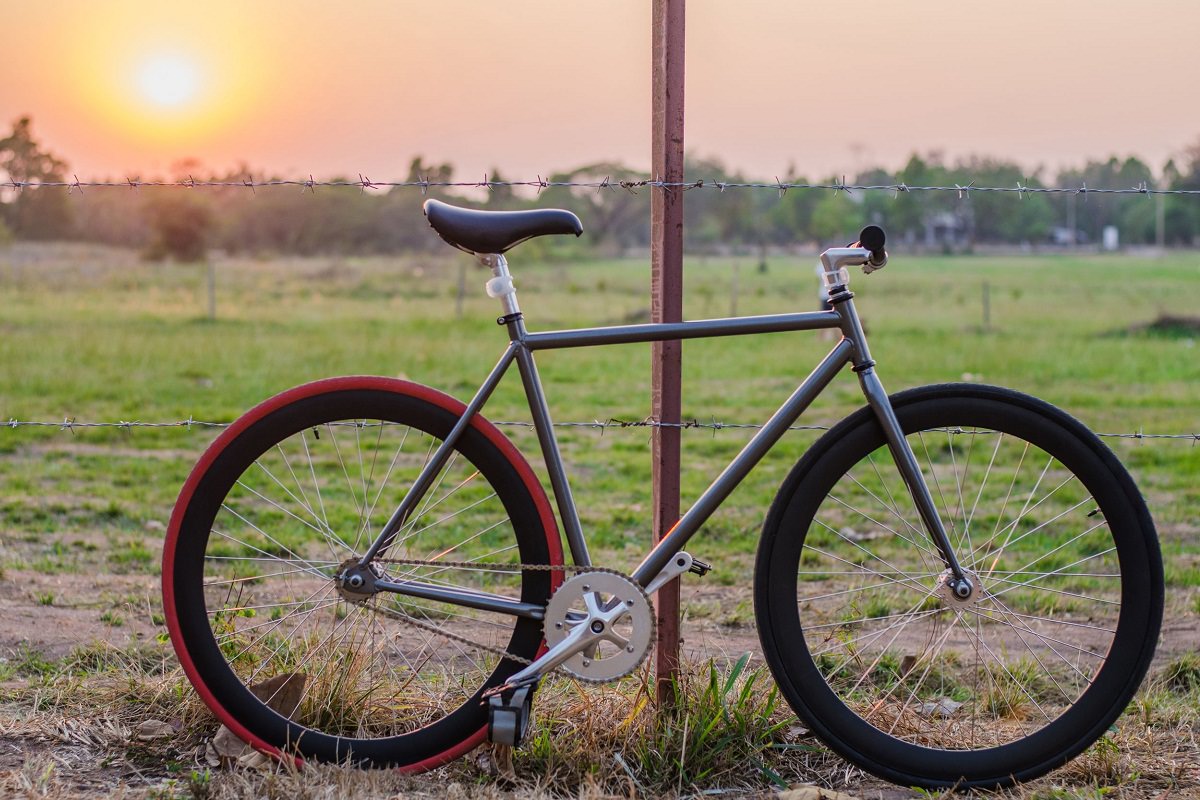 Bicycle parked in a field against the sunset