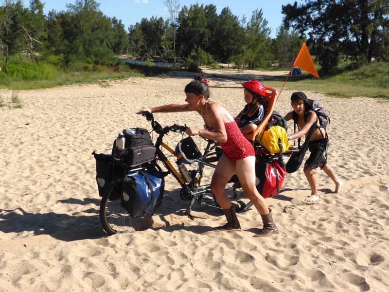 Walking with a bike through sand