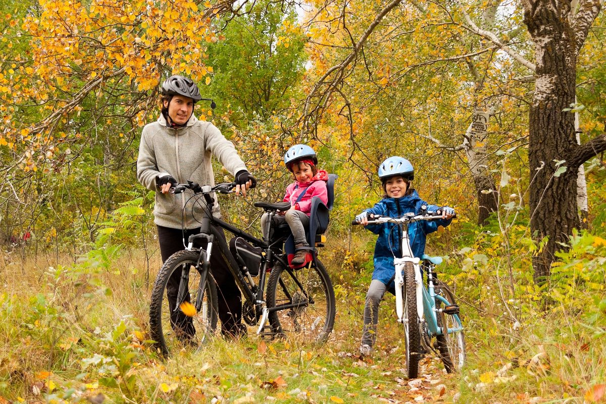 Father and children cycling together