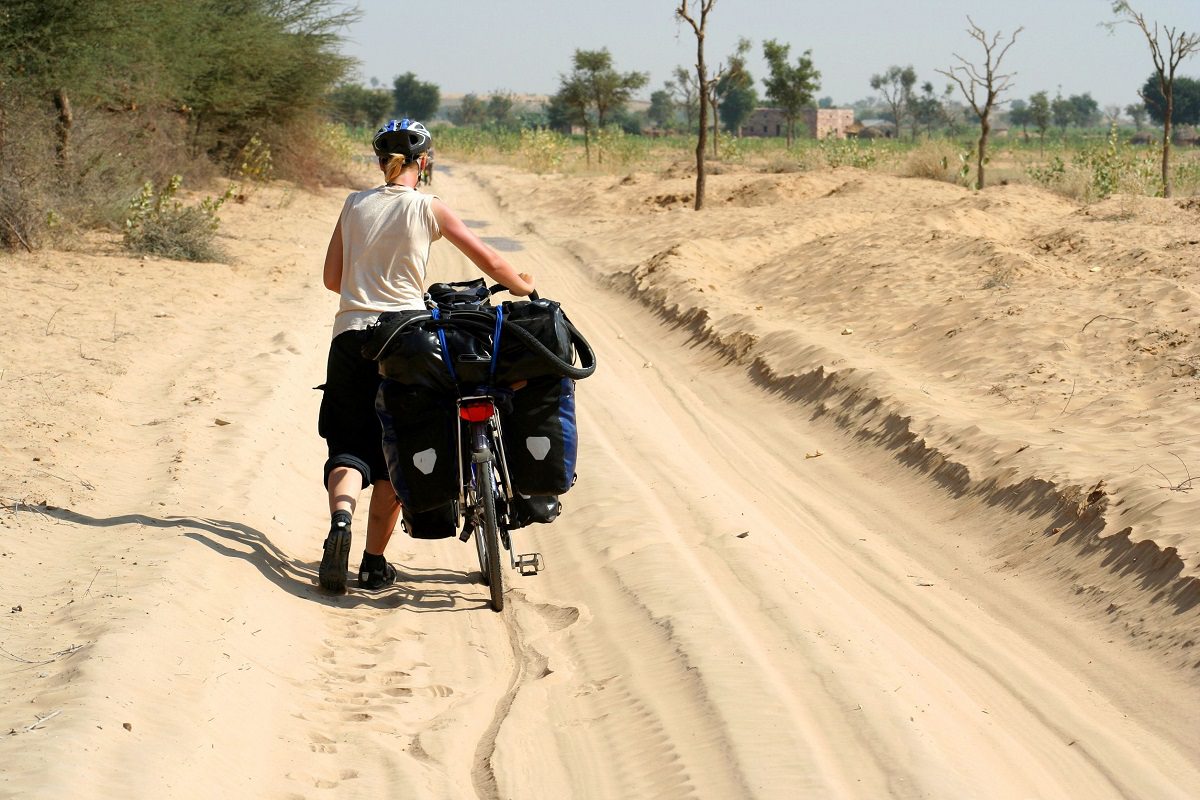 Walking with bike in a desert