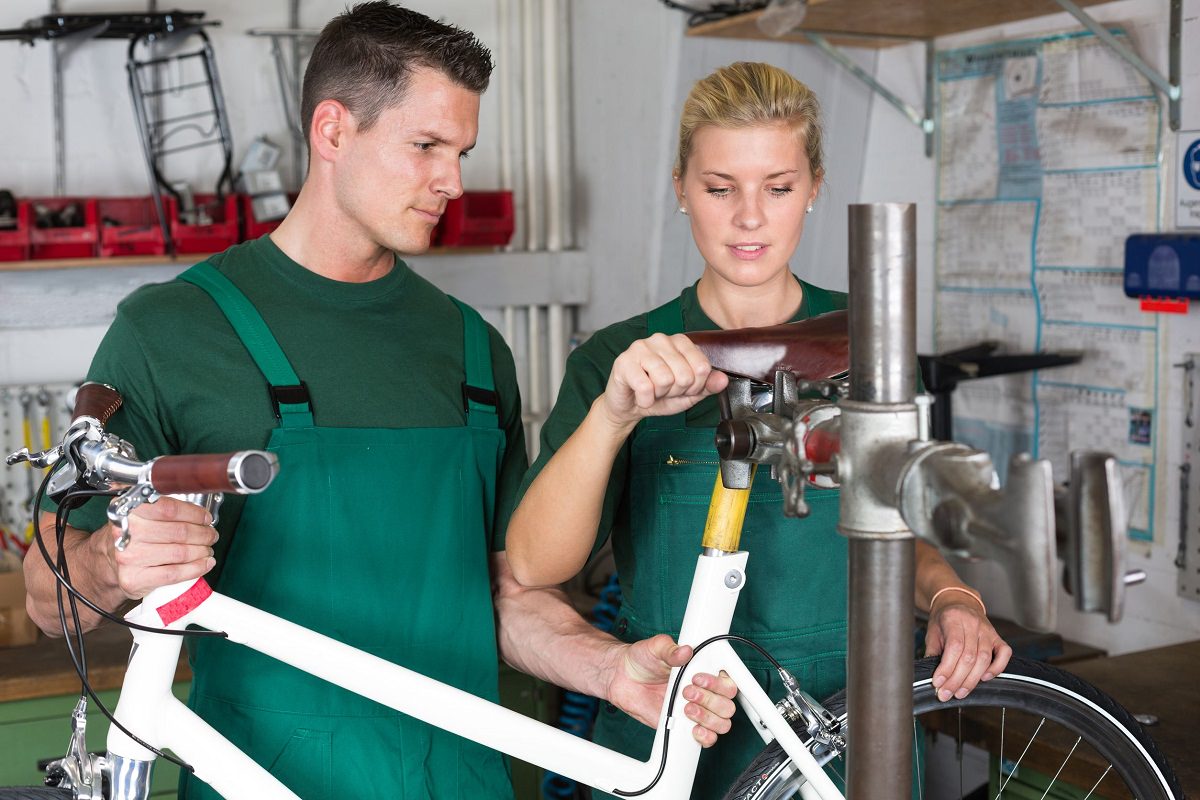 Mechanics repairing a bicycle in workshop