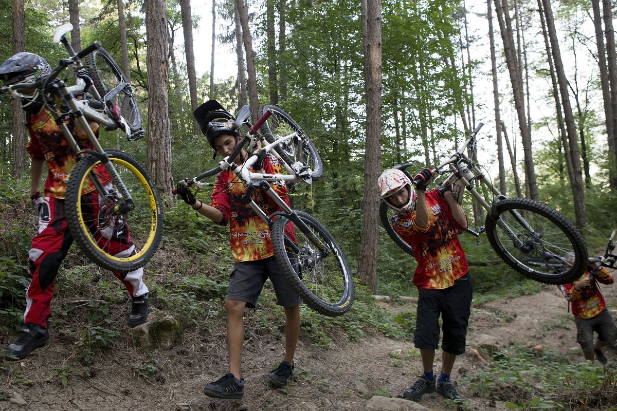 Mountain bikers carrying their bikes