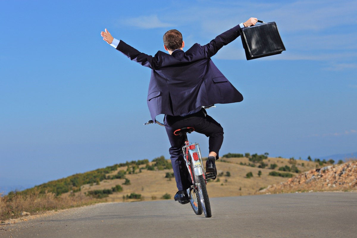 Carefree businessman on a bike