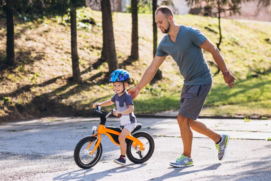 Father Teaching Son To Ride A Bike