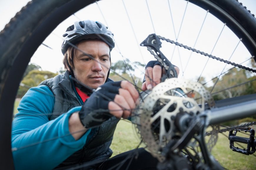 cyclist inspecting the bike chain