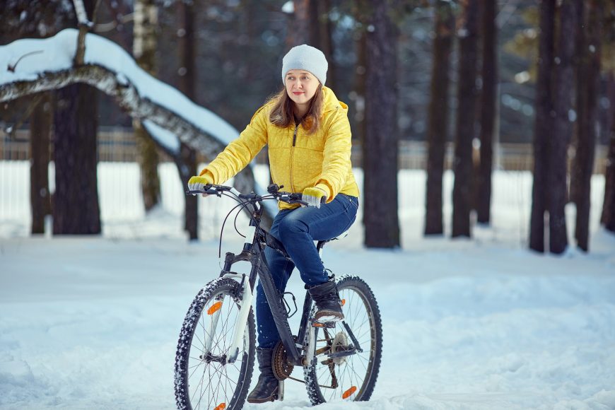 Woman Rides A Bicycle In The Snow