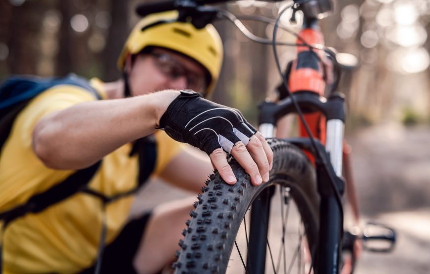 Cyclist Checking Bicycle Tire Pressure