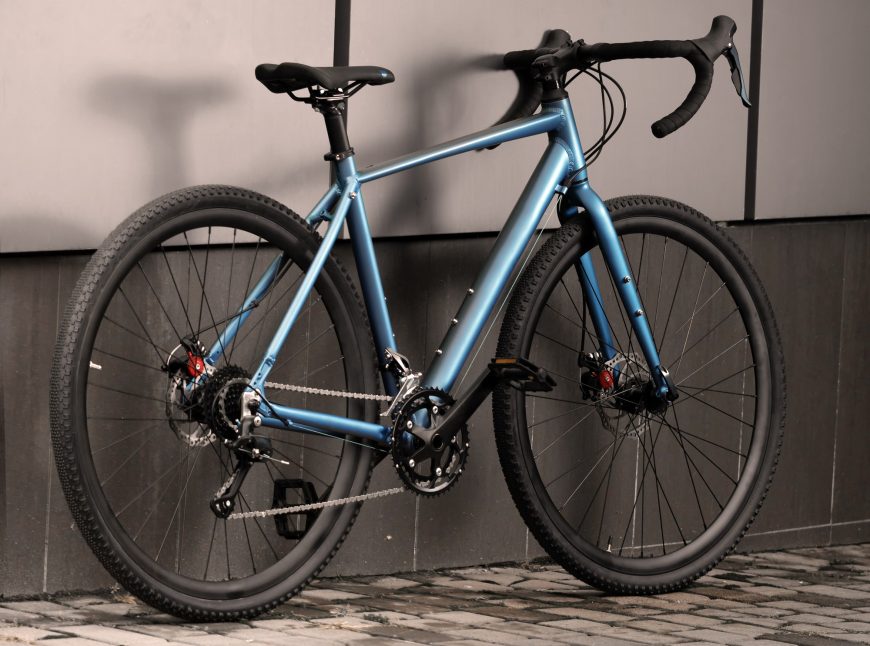 Gravel bike parked with a wall