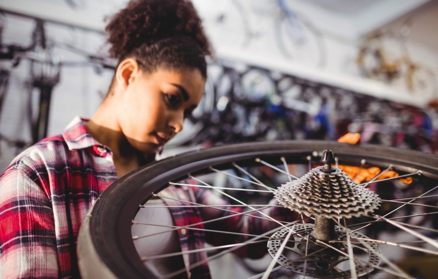 Mechanic Examining A Bicycle Wheel Mechanic Examining A Bicycle Wheel