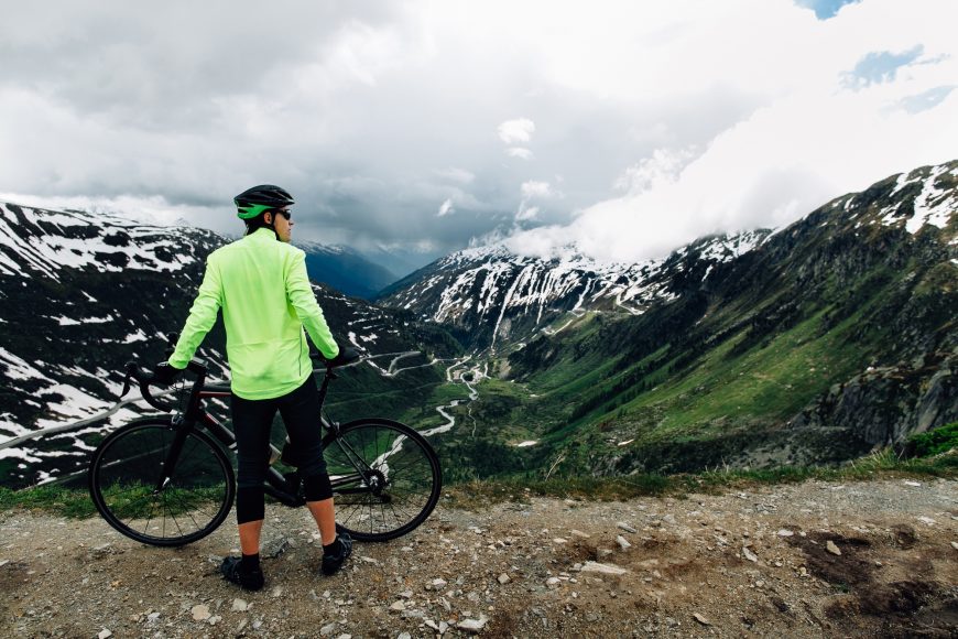 Cyclist Standing With Bike On Mountain