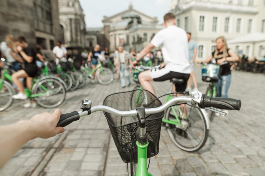 Cyclists On Bikes At Bike Sharing Station