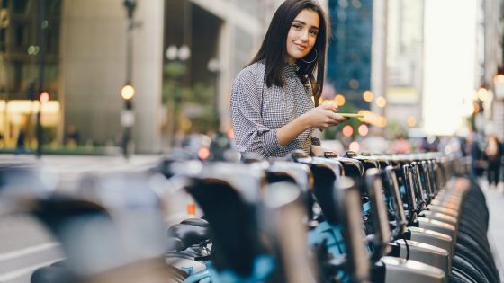 Girl Standing At Bike Sharing Stand