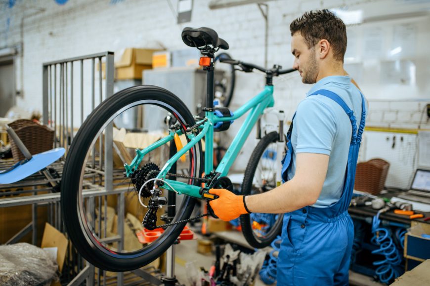 Mechanic Assembling Bike In A Workshop