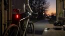Cyclist checking front bike light runtime before an evening commute.