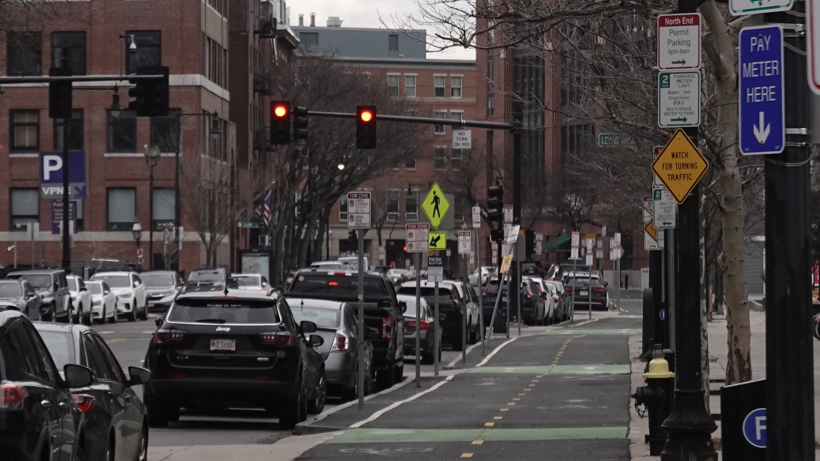 Sidewalk-level bike lane in Boston beside city traffic.
