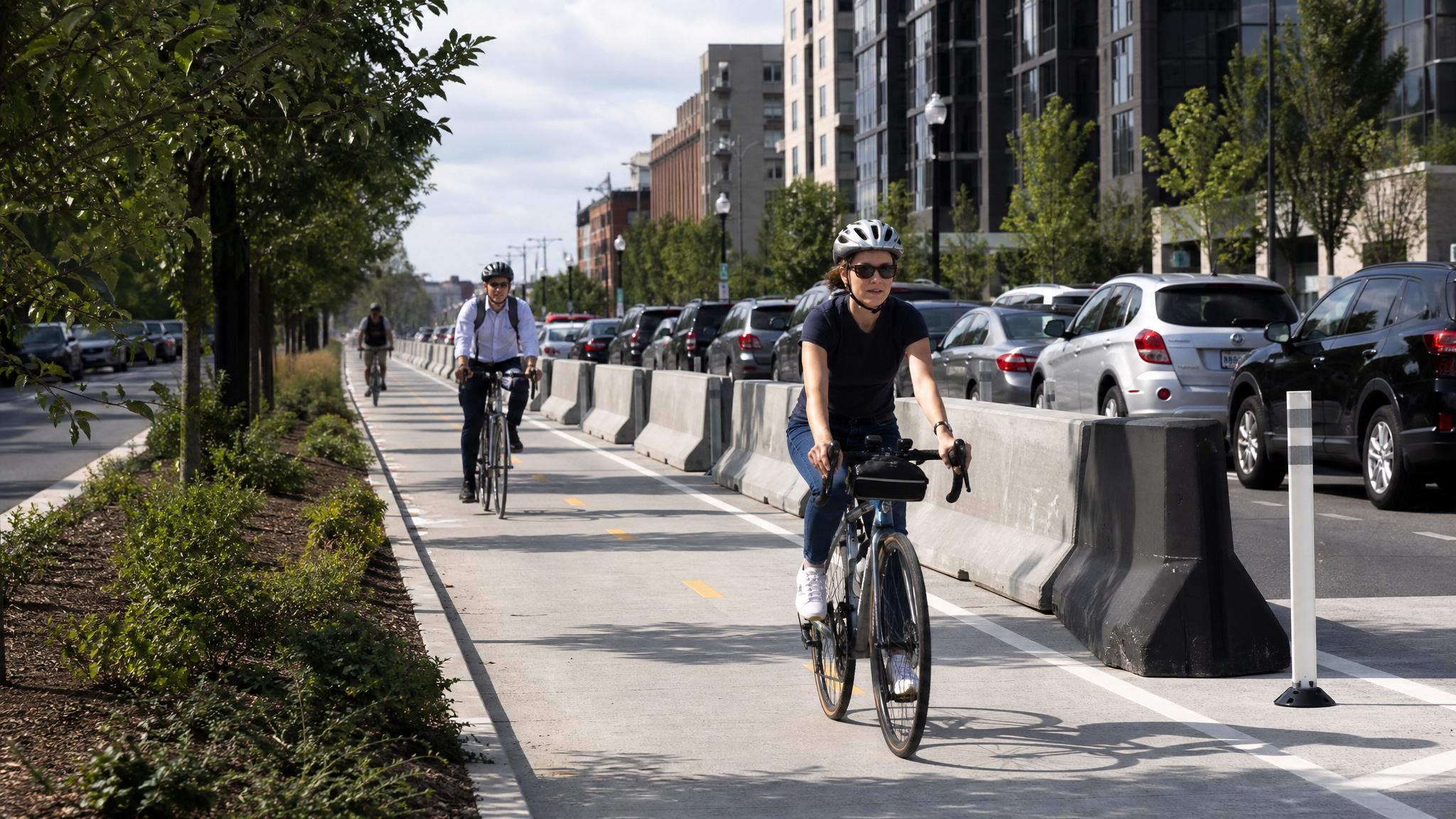 Generic cyclists riding in a concrete-protected urban bike lane