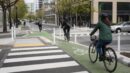 Cyclists riding through a protected urban bike lane at an intersection