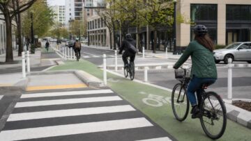 Cyclists riding through a protected urban bike lane at an intersection