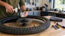 Cyclist adding tubeless sealant to a bike tire during maintenance.