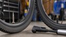 Three bicycle wheels showing Presta, Schrader, and Dunlop style valve stems.