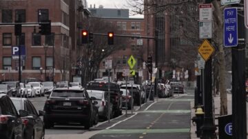 Cyclist riding on a city street used as an editorial visual for Illinois' Dutch Reach safety campaign story.