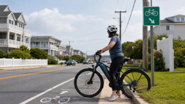 A rider on an e-bike beside a marked bike lane on a residential street.