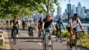 A group of everyday cyclists riding together on an urban bike path.